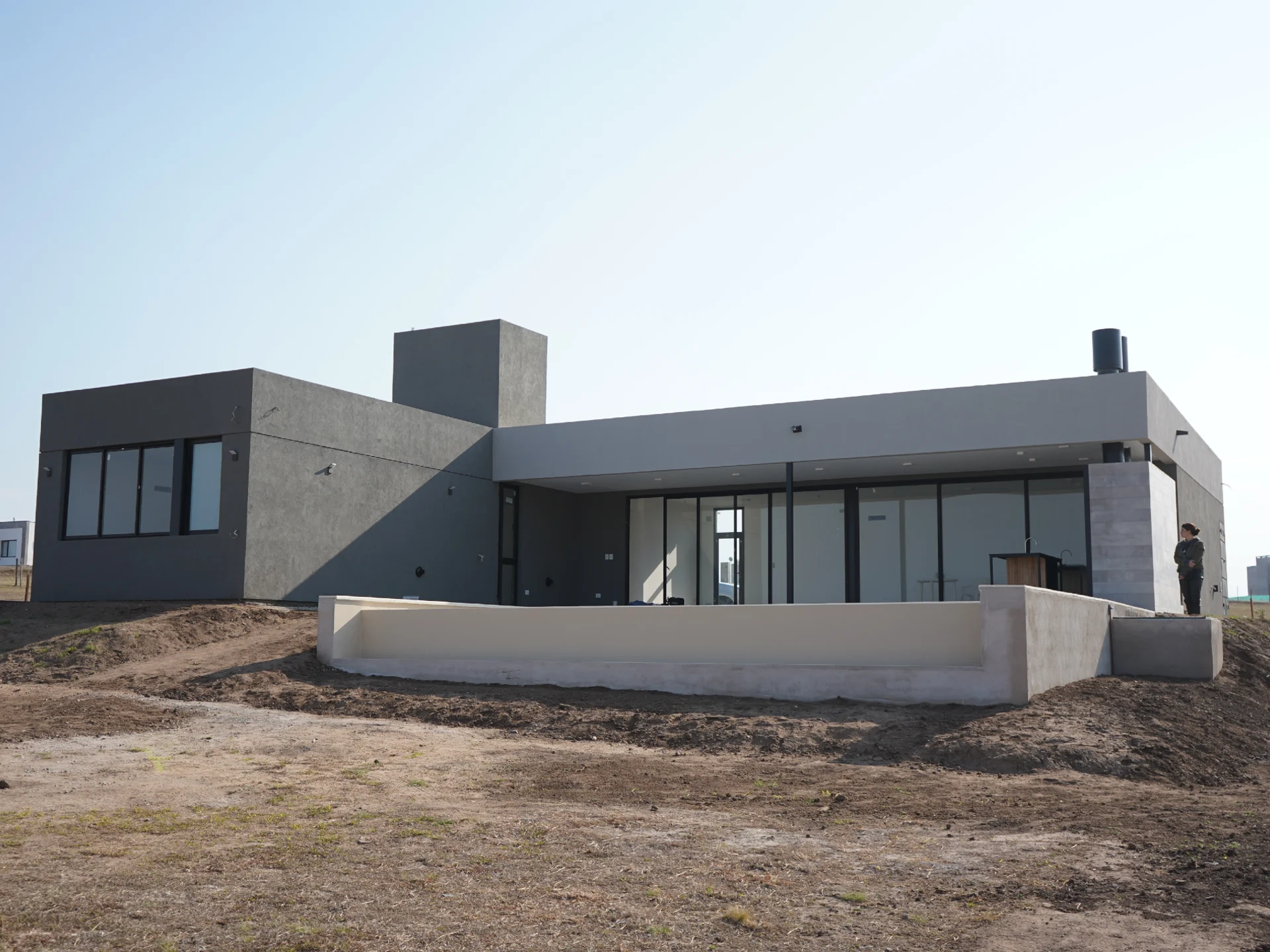 Foto de una casa en puerto del Águila construída con el sistema de Steel Framing por Vértice Construcciones en la que se observa la fachada frontal del lado derecho de la casa revestida con el sistema EIF's dándole una terminación final con revestimiento texturado