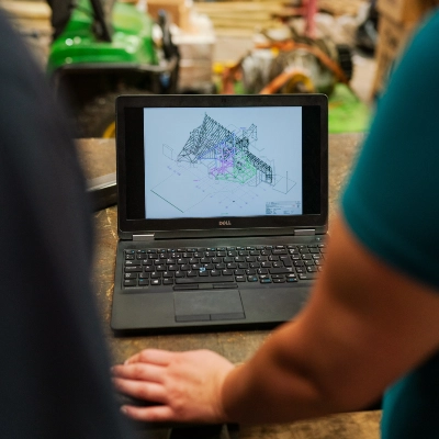 Foto de una computadora laptop en la que se visualiza un plano de una estructura con perfiles en 3D